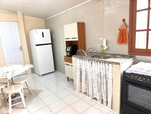 a kitchen with a sink and a refrigerator at Pe no Centro in Porto Seguro