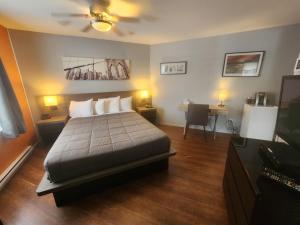 - une chambre avec un lit, deux tables et deux lampes dans l'établissement Motel Le Victo, à Victoriaville