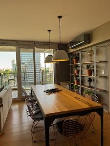 uma sala de jantar com mesa e cadeiras de madeira em Puerto Norte em Rosário