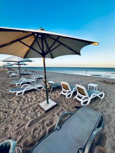 un gruppo di sedie e un ombrellone su una spiaggia di Mangrove M1-5B-13 a Banī Ghālib Altre 25 foto