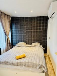 een slaapkamer met een groot bed met een geel voorwerp erop bij Duplex Montmorency à 30min de Paris in Montmorency