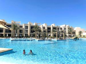 two people swimming in a swimming pool in a resort at Mangrove M1-5B-13 in Hurghada +24 photos