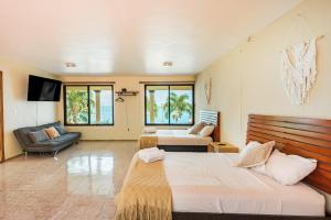 巴卡拉尔Casa Sirena - A orilla de la laguna y Cenote Esmeralda的一间带两张床和一张沙发的大卧室