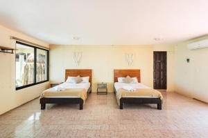 巴卡拉尔Casa Sirena - A orilla de la laguna y Cenote Esmeralda的配有两张床的房间的两张床