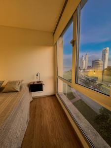 um quarto com uma grande janela com vista para a cidade em Puerto Norte em Rosário