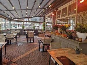 an empty restaurant with tables and chairs and a counter at De Eenhoorn in Oostburg +120 photos