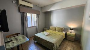 a small bedroom with a bed and a chair at HOTEL JUAN B JUSTO GARDEN Pet friendly in Mendoza +11 photos