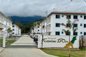 a white building with a fence in front of a street at Apartamento 2 Quartos com Ar Condicionado in Paraty +5 photos