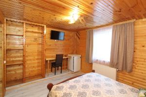 a bedroom with a bed and a desk and a television at Manor "U Bervinovy" in Yaremche