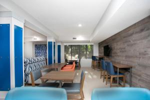 une salle à manger avec des tables, des chaises et un mur dans l'établissement Holiday Inn Express & Suites Jacksonville - Atlantic Beach by IHG, à Jacksonville
