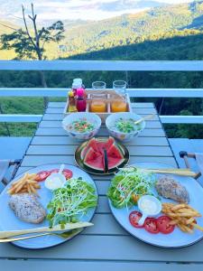 a table topped with plates of food on a table at Memory House ภูชี้ฟ้า เชียงราย in Ban Seng Choi