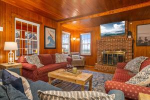 een woonkamer met rode meubels en een open haard bij Danemead Cottage - For 10ppl in Old Orchard Beach