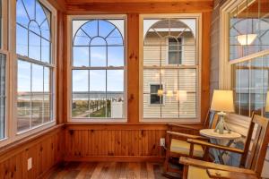 a room with windows and a table and a chair at Danemead Cottage - For 10ppl in Old Orchard Beach