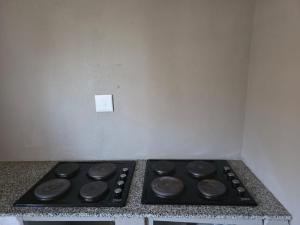 a stove top in a kitchen with a wall at Ngwanase Properties in Vosburg