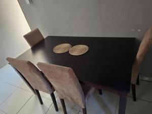 a black table with two chairs and two plates on it at Ngwanase Properties in Vosburg +5 photos