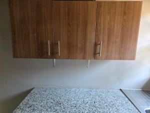 a kitchen with wooden cabinets on the wall at Ngwanase Properties in Vosburg