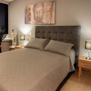 a bedroom with a large bed and two lamps at Hermoso apartamento loft cerca al segundo parque de laureles in Estación El Salto