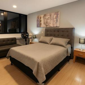 a bedroom with a large bed and a couch at Hermoso apartamento loft cerca al segundo parque de laureles in Estación El Salto +11 photos