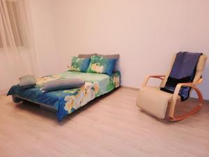 ein Bett und ein Stuhl in einem Zimmer in der Unterkunft Double rooms apartament in Sînpetru