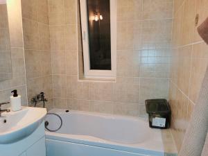ein Badezimmer mit Badewanne und Waschbecken in der Unterkunft Double rooms apartament in Sînpetru