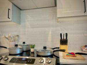 a kitchen with two pots and pans on a stove at Modern&Cozy Washer Dryer Pool Gym WorkerFriendly in Sherman +7 photos