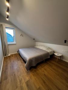 a bedroom with a bed and a window at Jūros namai in Palanga