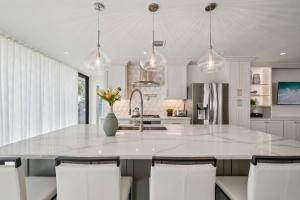 una cucina con ampia isola bianca con sedie bianche di Round Rock Lakeside Retreat a Round Rock Altre 25 foto