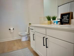 a bathroom with a white sink and a toilet at Modern A plus Location KINGbed pool gym in Sherman +5 photos