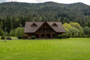a large log cabin in a field of green grass at Zrub Raj in Liptovský Ján