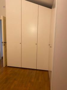 a closet with white cabinets and a wooden floor at Landi House in Uzzano