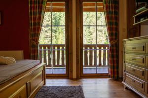 a bedroom with a bed and two large windows at Zrub Raj in Liptovský Ján +13 photos