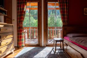 a bedroom with a bed and a window and a stool at Zrub Raj in Liptovský Ján
