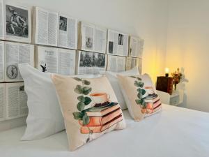un letto con due cuscini e una pila di libri di Mood Lodging Verso - Townhouse style home a Óbidos