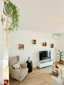 un soggiorno con sedia e TV di Mood Lodging Verso - Townhouse style home a Óbidos