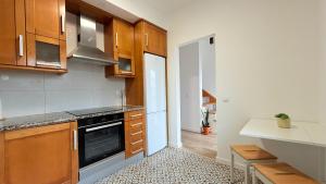 a kitchen with wooden cabinets and a stove top oven at Mood Lodging Verso - Townhouse style home in Óbidos