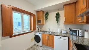 una cucina con lavello e lavatrice di Mood Lodging Verso - Townhouse style home a Óbidos Altre 35 foto