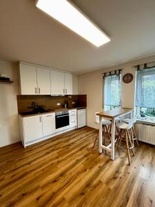 BermatingenにあるSpatzennest am Bodenseeの白いキャビネットと木製の床を備えたキッチン