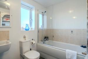 a bathroom with a toilet and a tub and a sink at Spacious Cotswolds Base, Private Garden & Parking in Evesham