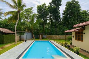 a swimming pool in the backyard of a house at Kurulu Garden Hotel in Ahungalla