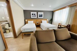 a hotel room with a couch and a bedroom at Mediterrâneo Flat in Rio de Janeiro