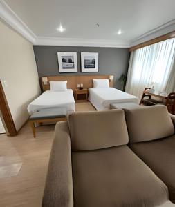 a living room with two beds and a couch at Mediterrâneo Flat in Rio de Janeiro