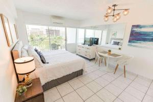 a bedroom with a bed and a table and a television at Waikiki Shore 1014 in Honolulu
