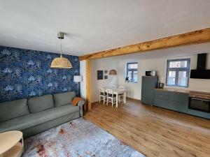 a living room with a couch and a table at Fachwerkzeit Haus mit zwei Apartments in Quedlinburg