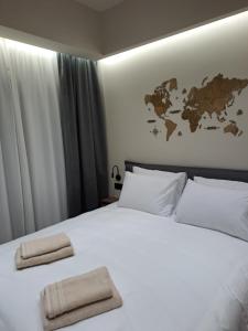 een slaapkamer met een wit bed en een kaart aan de muur bij Serenity Luxury Apartment 2 in Alexandroupoli