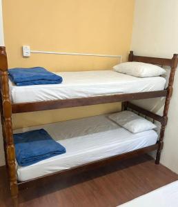 deux lits superposés dans un dortoir avec des serviettes dessus dans l'établissement Pousada Vermont, à Maringá