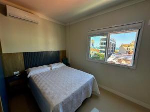 a small bedroom with a bed and a window at Vieques in Bombinhas +18 photos