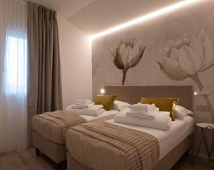 a bedroom with two beds with white sheets and yellow pillows at Residenza Galileo -affittacamere Padova sud in Albignasego