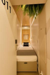サンパウロにあるCapsula Hotel Sao Paulo - Paulistaの小さな部屋にベッドが置かれた小さな寝室