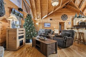 - un salon avec un arbre de Noël dans une cabane en rondins dans l'établissement Moose Mountain Lodge by American Patriot Getaways, à Glade
