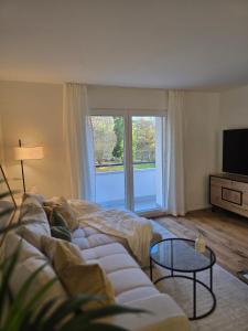 salon z białą kanapą i telewizorem w obiekcie Urban Comfort, Zurich Airport - By River Glatt w mieście Opfikon